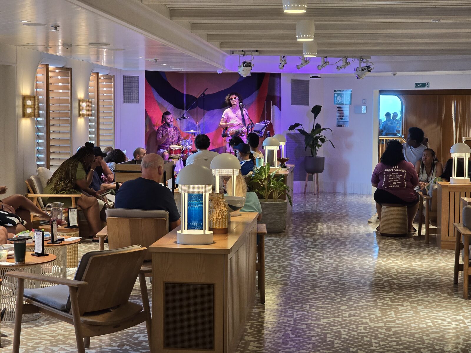 A relaxed lounge scene with live acoustic music at The Dock House on Virgin Voyages