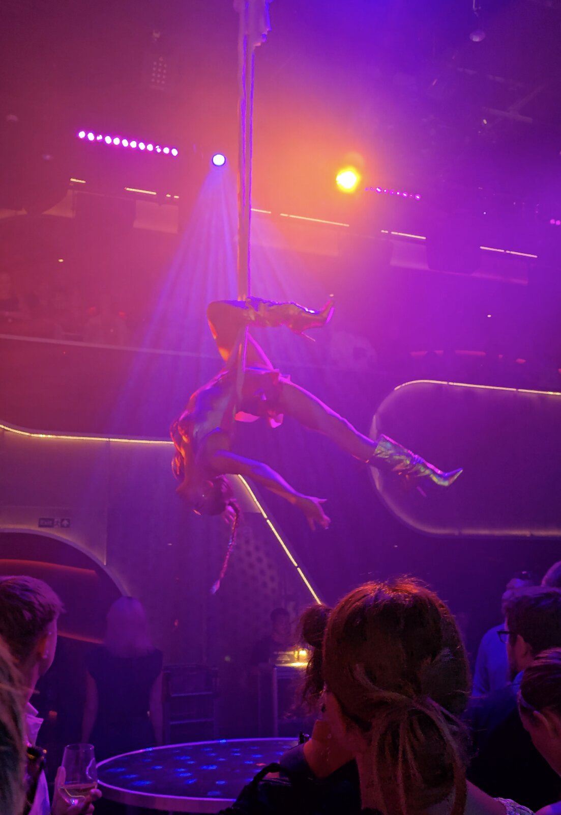 An aerial performer during the Persephone show on Virgin Voyages, seen from the floor-standing crowd