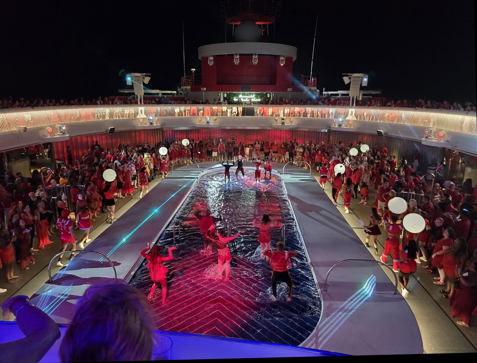 A packed pool deck party during Scarlet Night on Virgin Voyages
